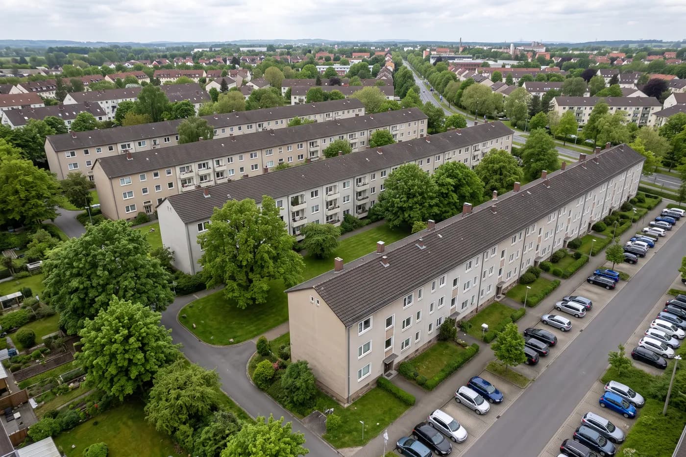 Wohnsiedlung mit vier gleichartigen Zeilenbauten und Grünflächen