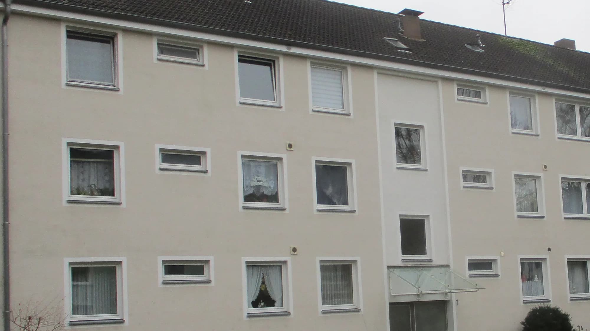 Dasselbe Mehrfamilienhaus nach der chemiefreien Fassadenreinigung, heller und gleichmäßiger Putz